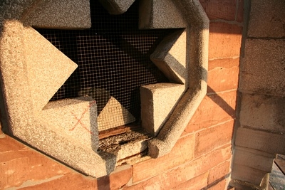 Hier sieht man eine solche Rosette.
Sechs von acht Rosetten sind aus Beton.
Durch die filigrane Form, liegt an vielen Stellen die Stahlarmierung viel zu weit au&szlig;en und hat begonnen zu rosten.

Das rote X markiert solche Steine, die ersetzt werden m&uuml;ssen.