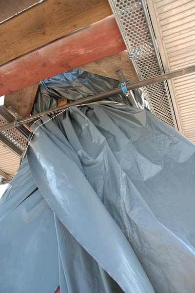 Damit man den Beton sanieren kann, muss dieser absolut trocken sein.
Die lange Trockenperiode, die die Gartenbesitzer in den letzten Wochen zum st&auml;ndigen W&auml;ssern gezwungen haben, hat den Beton am Turm bis in den letzten Riss ausgetrocknet.

Ideale Voraussetzungen f&uuml;r eine Sanierung.
Damit dies so bleibt, wurde der Helm mit einer Bauplane vor Regen und Feuchtigkeit gesch&uuml;tzt.