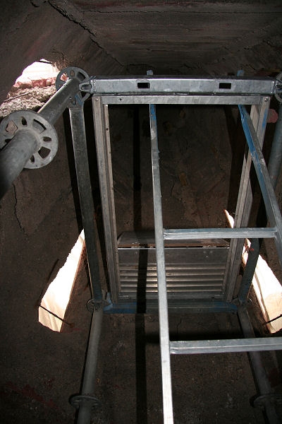 Dadurch dass kein Frischluftaustauch stattfinden konnte, blieb die Feuchtigkeit in der Luft und kondensierte bei der n&auml;chsten Abk&uuml;hlung wieder am Beton.

Das kann im Herbst und im Fr&uuml;hjahr t&auml;glich geschehen, da die Temperaturunterschiede zwischen Tag und Nacht hier sehr gro&szlig; sein k&ouml;nnen.

Hier m&ouml;chte ich nochmals den Vergleich mit dem Badezimmer heranziehen:

Nach dem Baden sind Spiegel und Fliesen beschlagen. Was macht man dagegen?
Richtig! Wir &ouml;ffnen das Fenster und in k&uuml;rzester Zeit kann die Feuchtigkeit nach au&szlig;en entweichen.
Lassen wir die Fenster hingegen st&auml;ndig geschlossen, so bildet sich fr&uuml;her oder Sp&auml;ter Schimmel an der Decke â wegen der st&auml;ndigen Feuchtigkeit.

Im Turm hat sich zwar kein Schimmel gebildet, aber der Beton zerf&auml;llt eben nach und nach. Auch die Eisentr&auml;ger beginnen zu rosten.

Vor der Sanierung musste nun also zuerst eine L&ouml;sung f&uuml;r dieses Problem gefunden werden.
Und diese war, wenn man an die Badezimmeranalogie denkt, einfach: âFensterâ
Nat&uuml;rlich keine richtigen Fenster, aber eben 4 L&uuml;ftungs&ouml;ffnungen im oberen Bereich des Turmhelmes. Diese m&uuml;ssen abschlie&szlig;end nat&uuml;rlich noch verblecht werden so, dass die Luft zwar frei zirkulieren kann, aber auch bei starken Windb&ouml;en kein Regenwasser in den Turm gelangen kann.
